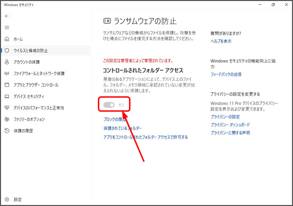 Windowsセキュリティの「ランサムウェアの防止」設定画面。「コントロールされたフォルダーアクセス」機能が「オン」になっており、赤い矢印でそのスイッチが指し示されている。「この設定は管理者によって管理されています」という注意書きも表示されている。
